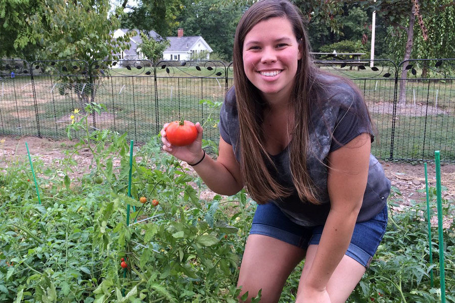 Kent State master’s student Sarah Burns shows off a tomato from the garden behind Nixson Hall. 
