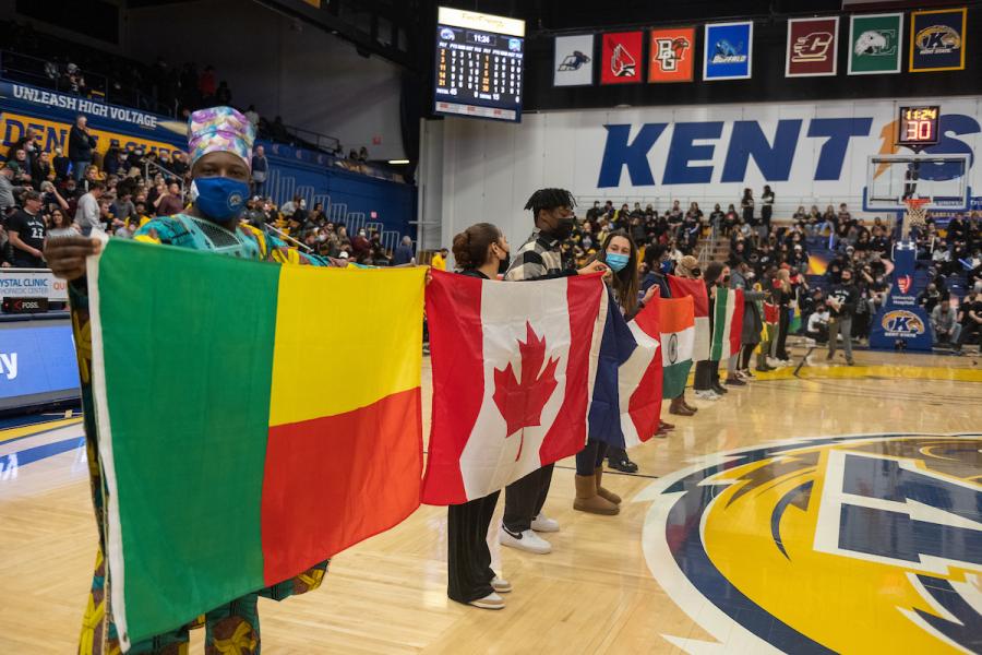 International students with flags at a Kent State basketball game.