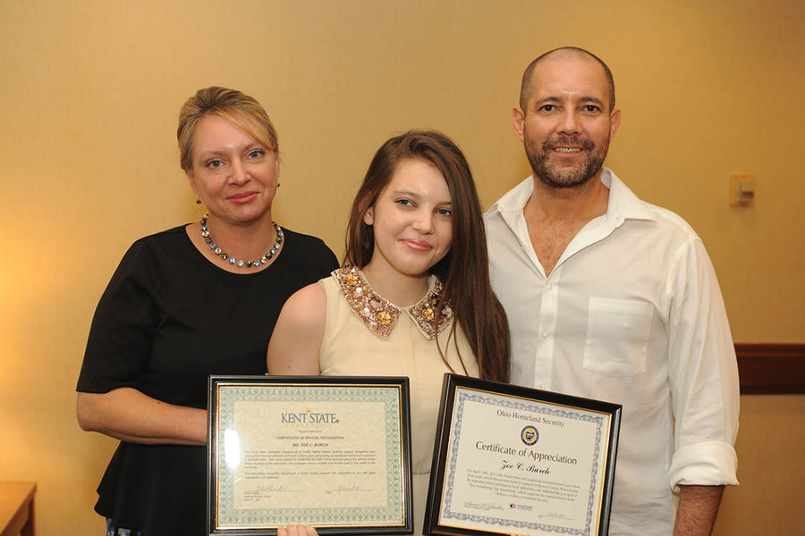 Kent State student Zoë Burch poses with her parents, Michele and Daniel Burch. Zoë received certificates from the Kent State Police Department and Ohio Homeland Security for reporting a potential threat she saw online.