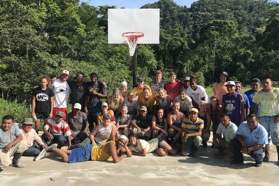 The Kent State Golden Flashes pose with members of the community on the multipurpose court they constructed in Aguacate, Belize.