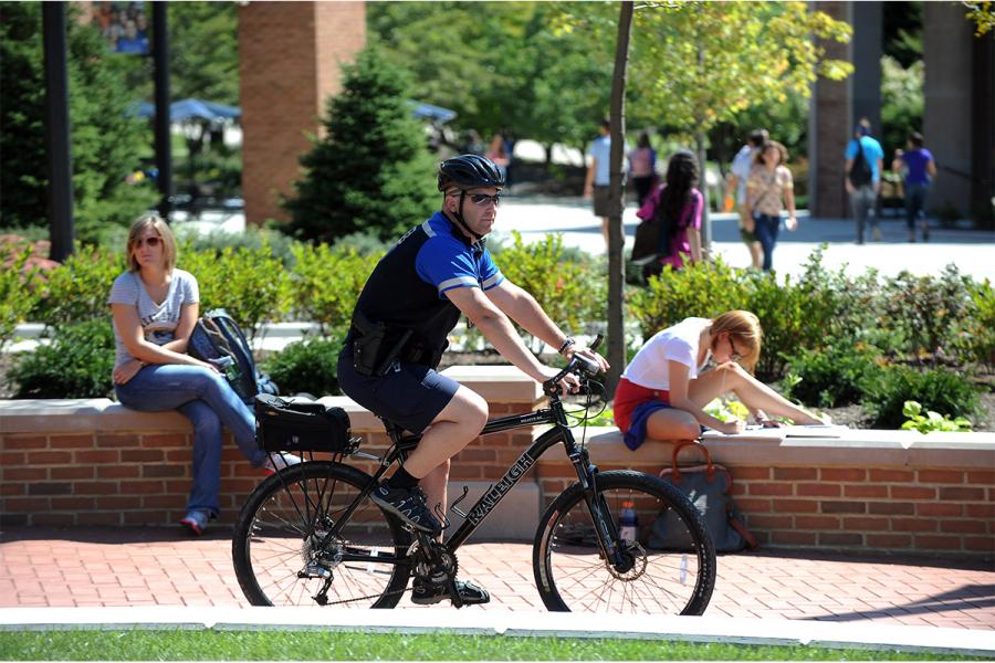 Jeff Futo, a member of the Kent State Police Department, rides a bike through the Risman Plaza while on day time patrol. Bikes are one of the easiest modes of getting from one end of campus to the other and are used by the police as the weather allows.