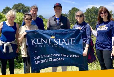 Photo of alumni holding a Kent State banner