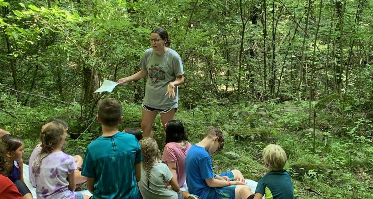 Honors student Olivia Eader takes a group of children on a hike through the woods as part of her summer research for the SURE Program.