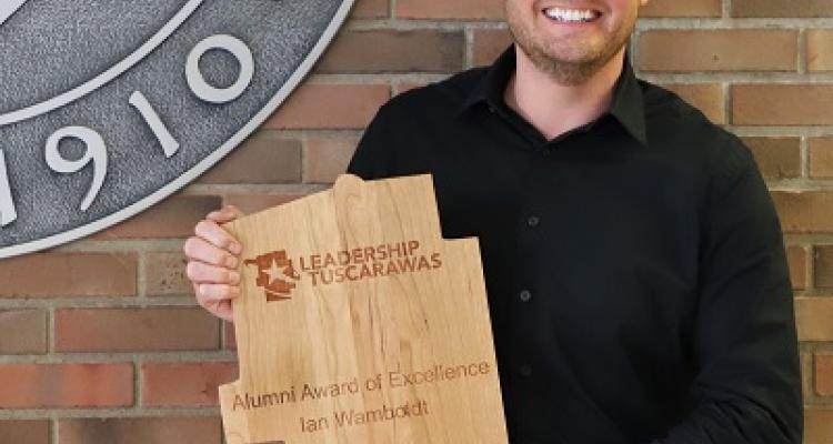 Ian Wamboldt holding plaque for Leadership Tuscarawas Alumni Award of Excellence