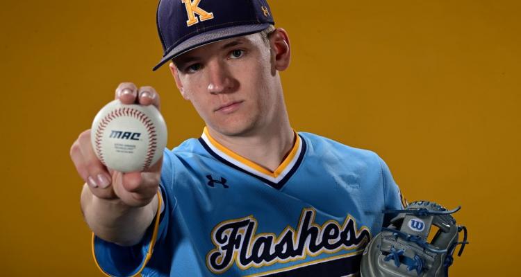 Honors College student Richie Dell poses in his baseball uniform holding a baseball.