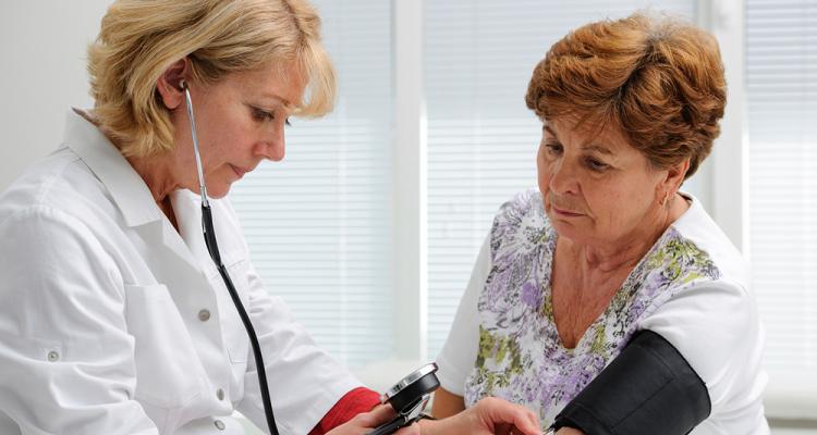 An Adult Gerontology Primary Care Nurse Practitioner takes a geriatric patient's blood pressure