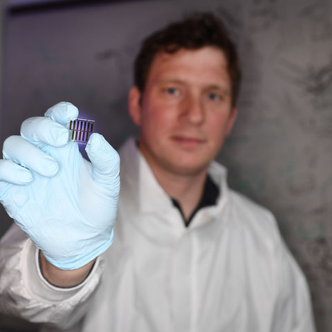 Bjorn Lussem holds on of the many organic transistors he studies in his lab