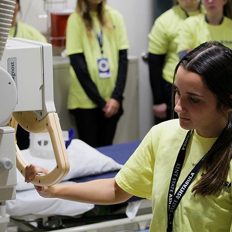A female student gets hands-on experience of the radiologic technology equipment during the Ashtabula Campus's Flash Medical Center event