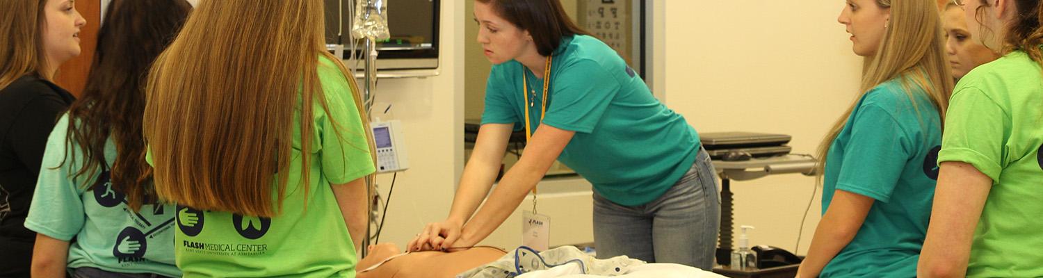 Student performing CPR on a medical simulation mannequin