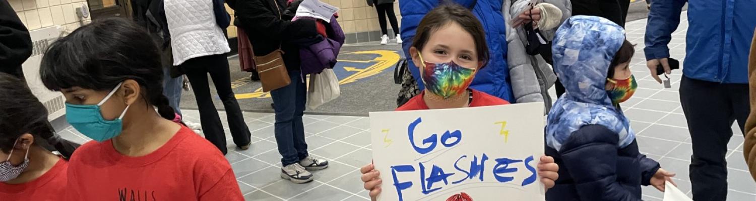 young student holding go flashes sign in support of women's basketball