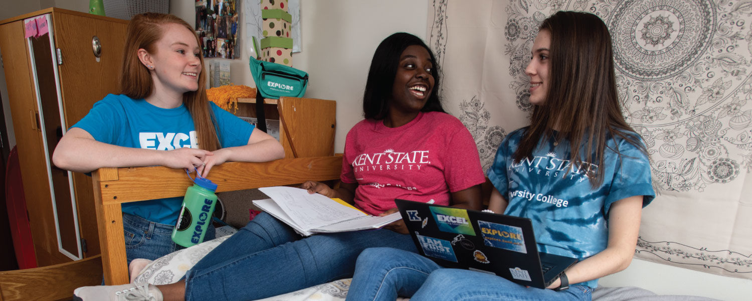 Three students sitting in dorm room.