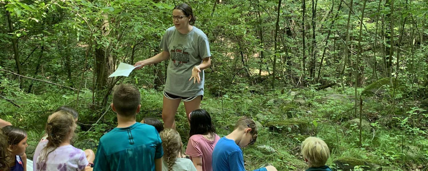 Honors student Olivia Eader takes a group of children on a hike through the woods as part of her summer research for the SURE Program.