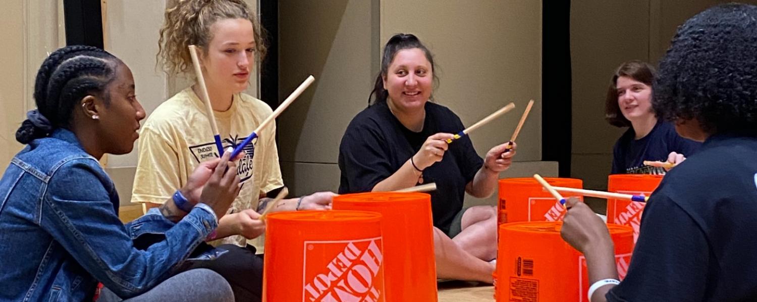 Students sitting down playing the drums