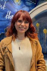 Miranda Beaujon smiling in front of an Van Gogh background
