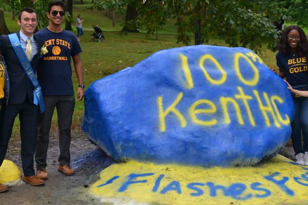Students standing by the Spirit Rock painted with '100th Kent HC'