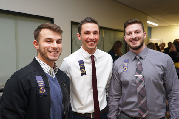 Three male nursing students celebrate the completion of their degrees following their Convocation pinning ceremony