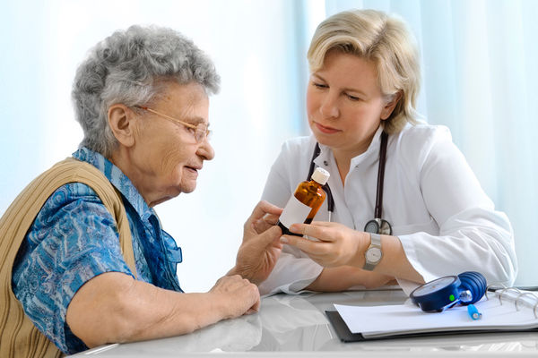 A Nurse Practitioner shows an elderly patient her medicine dosage