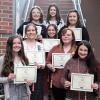 Eight nursing students holding certificates for Nursing Honor Society induction
