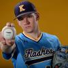 Honors College student Richie Dell poses in his baseball uniform holding a baseball.